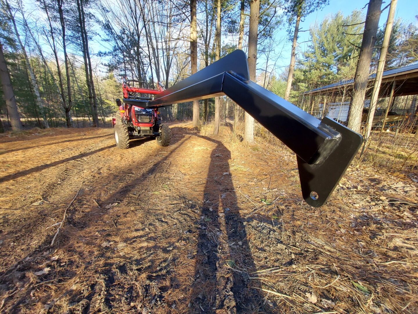 A tractor is pulling a plow through the woods.