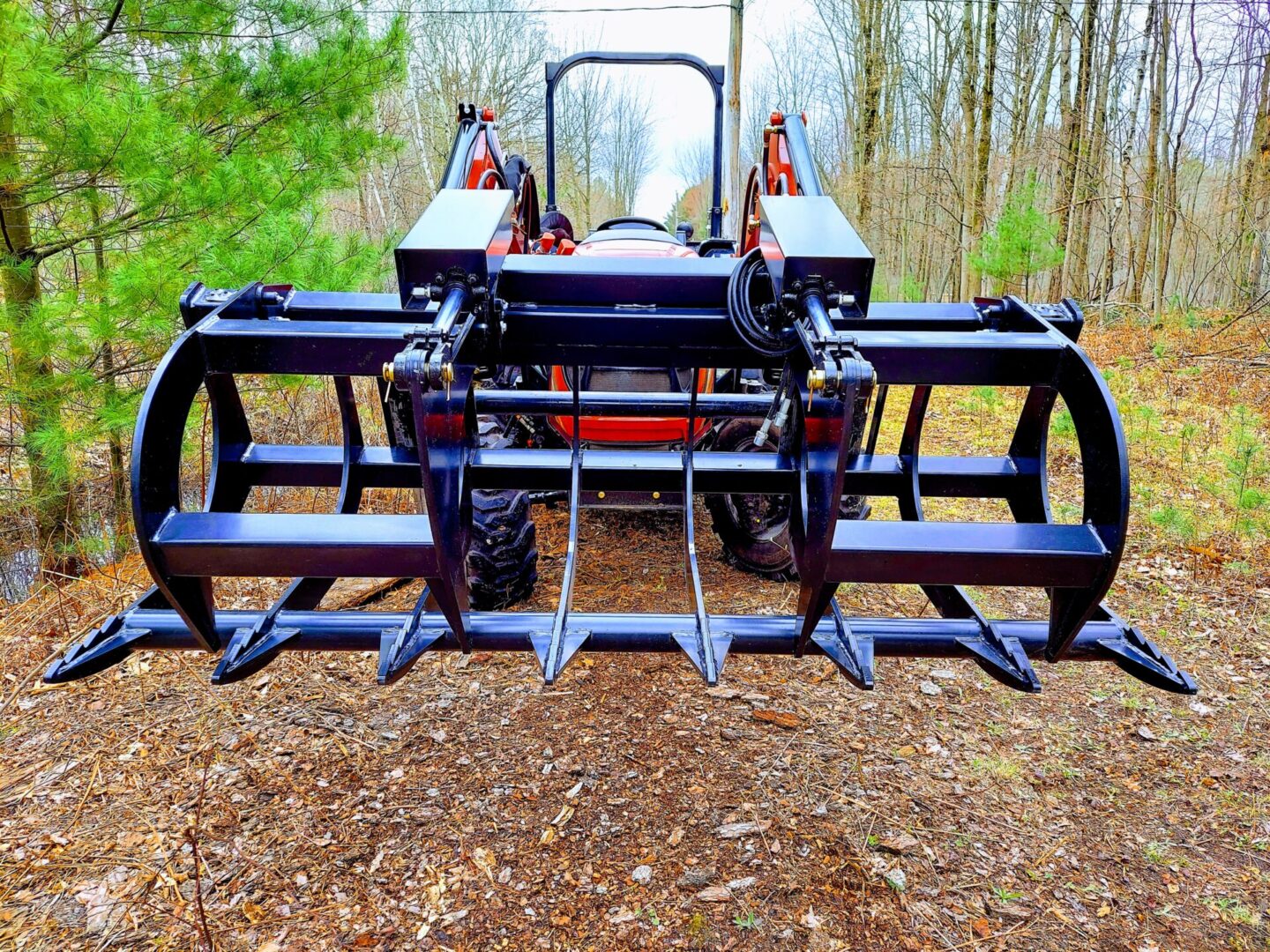 A tractor with two forks attached to it.