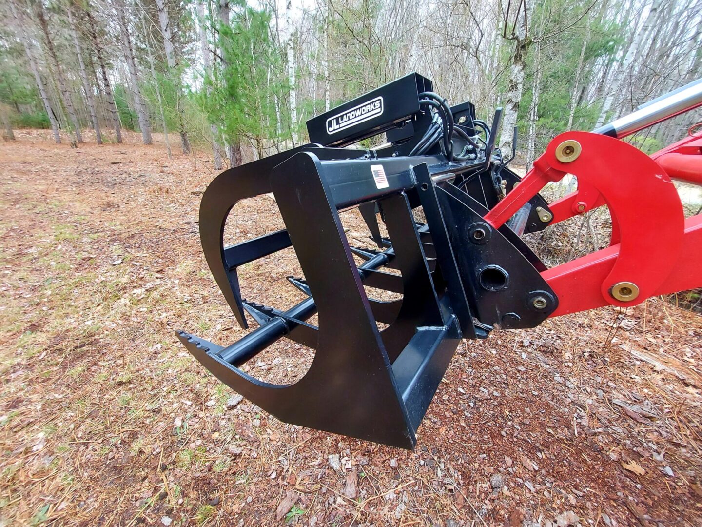 A red and black tractor with a tree in the background