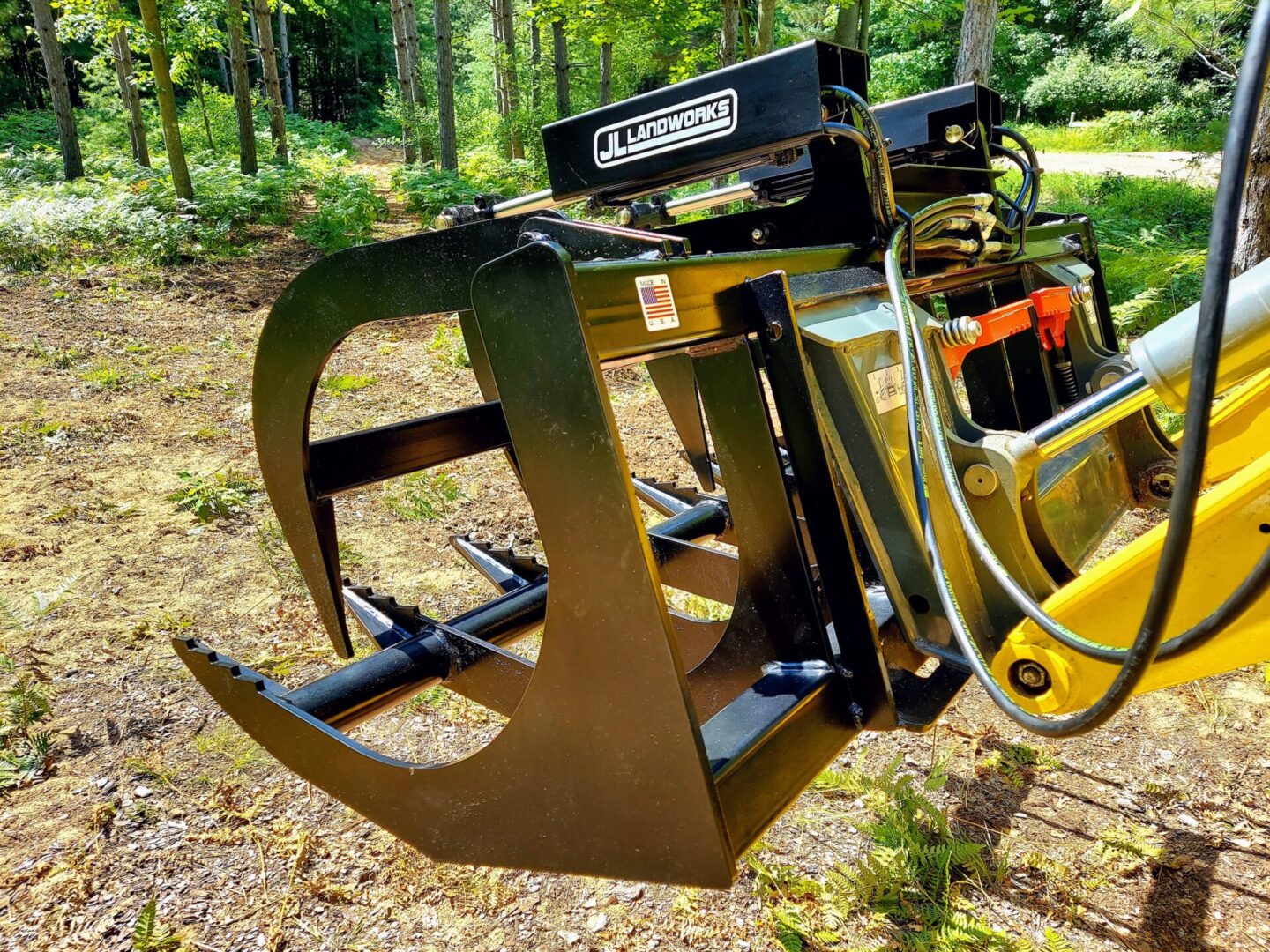 A yellow and black tractor with a tree in the background