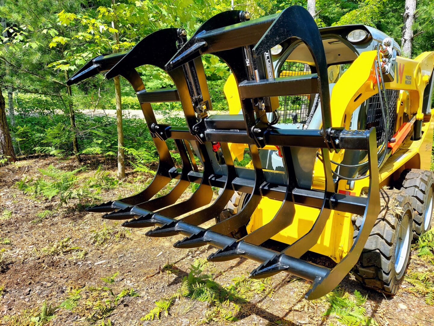 A yellow and black tractor with several attachments.