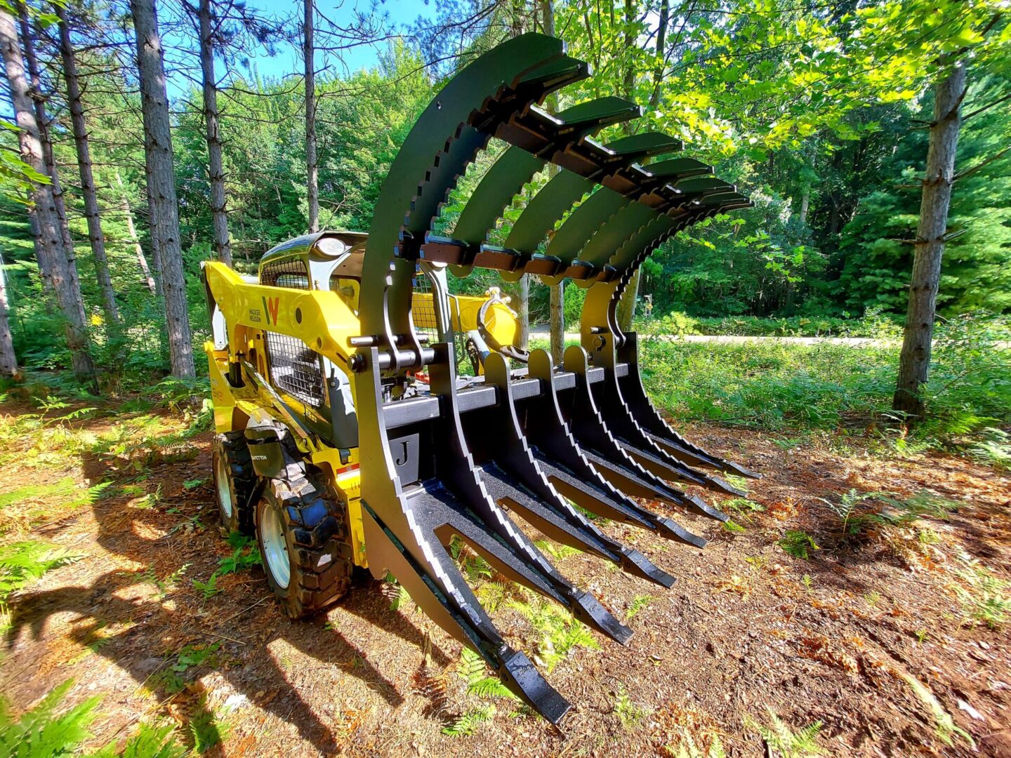 A yellow and black tractor with large forks