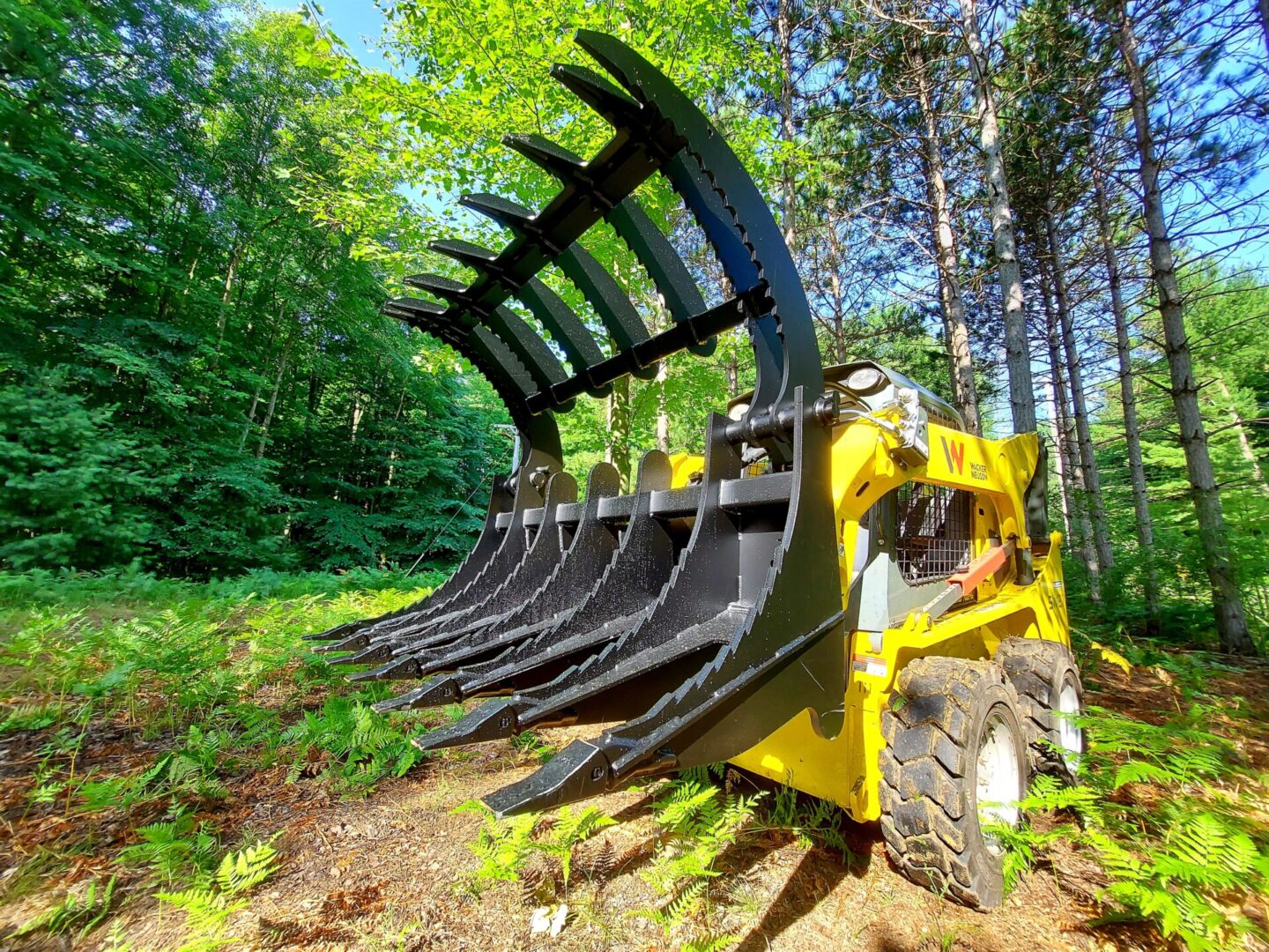 A yellow and black tractor with a large claw.