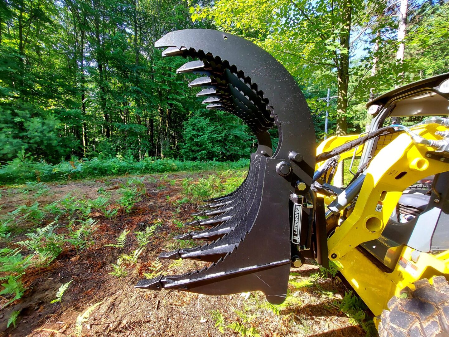 A yellow and black tractor with a large claw.