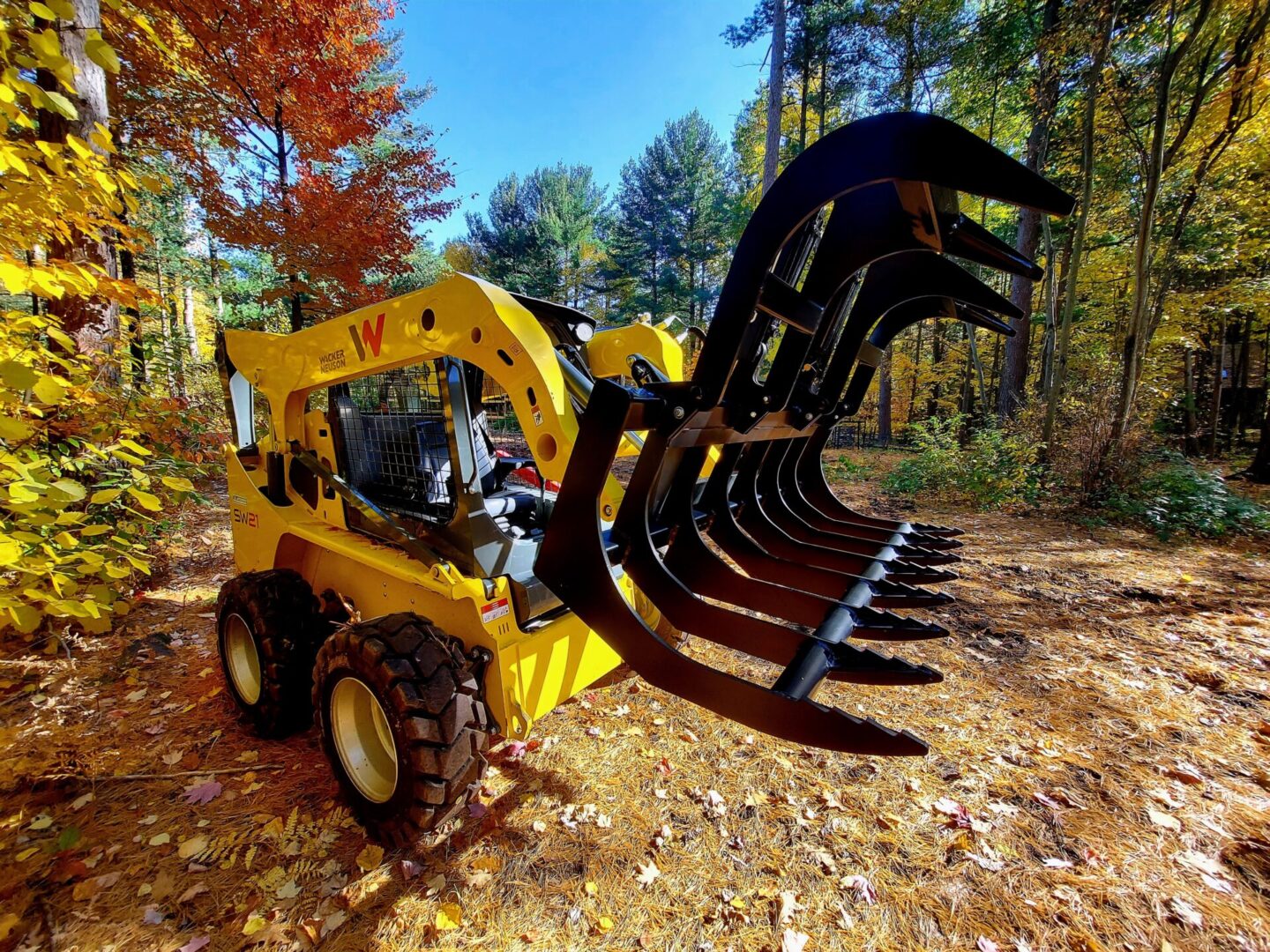 A yellow and black tractor with a large claw.