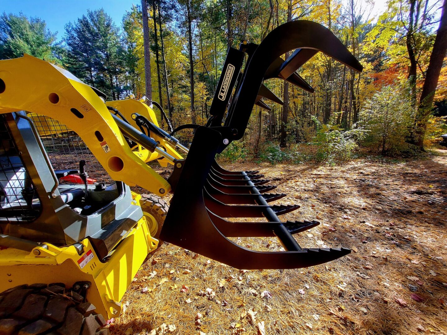 A yellow and black tractor with a large claw.