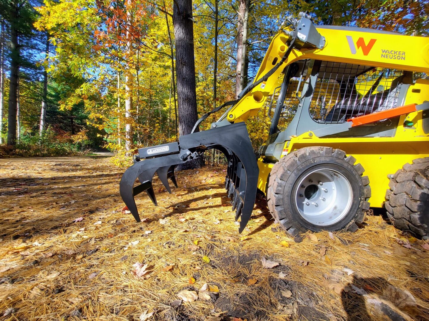 A yellow and black tractor is in the woods