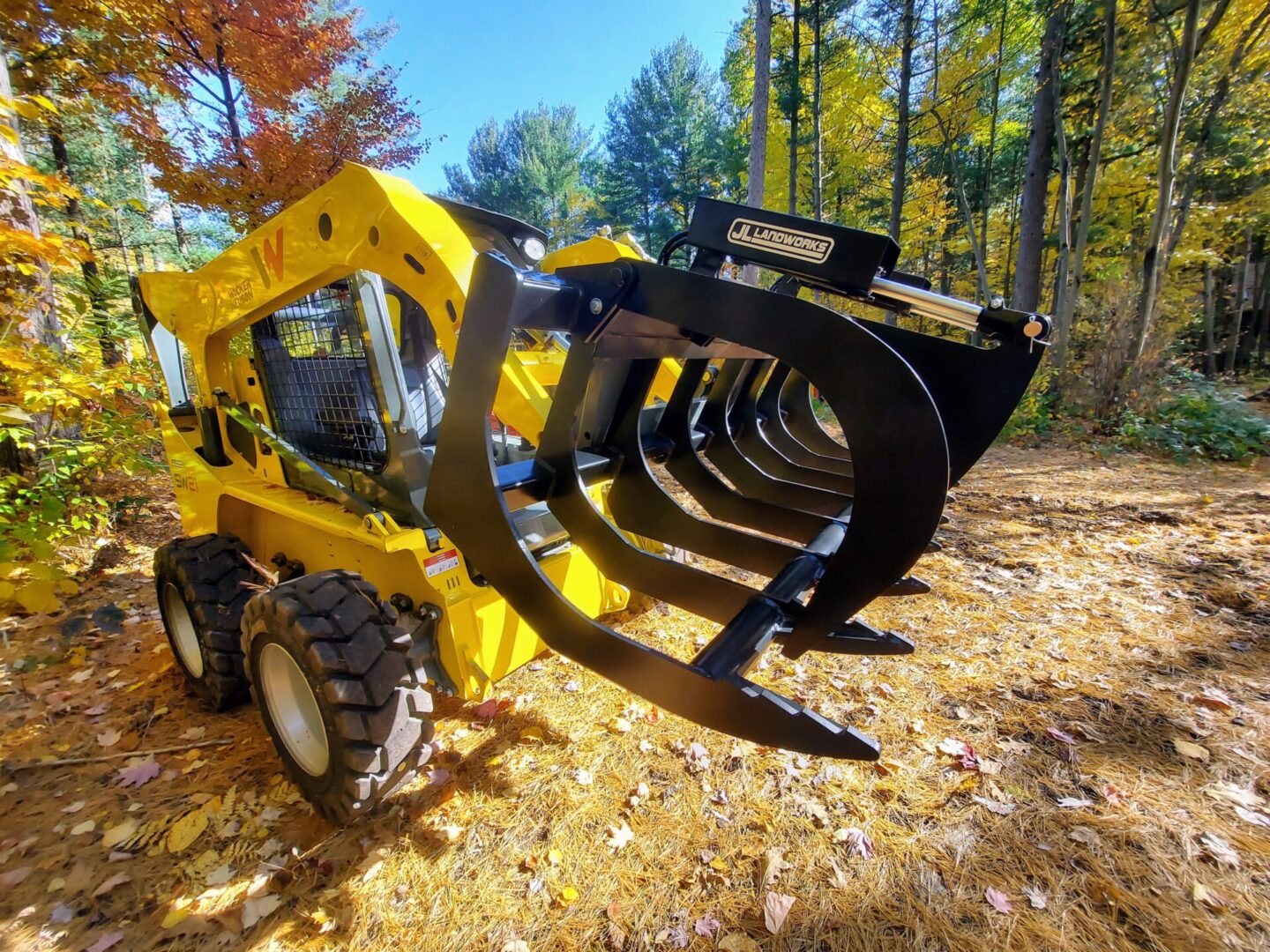 A yellow and black tractor with a large claw attachment.