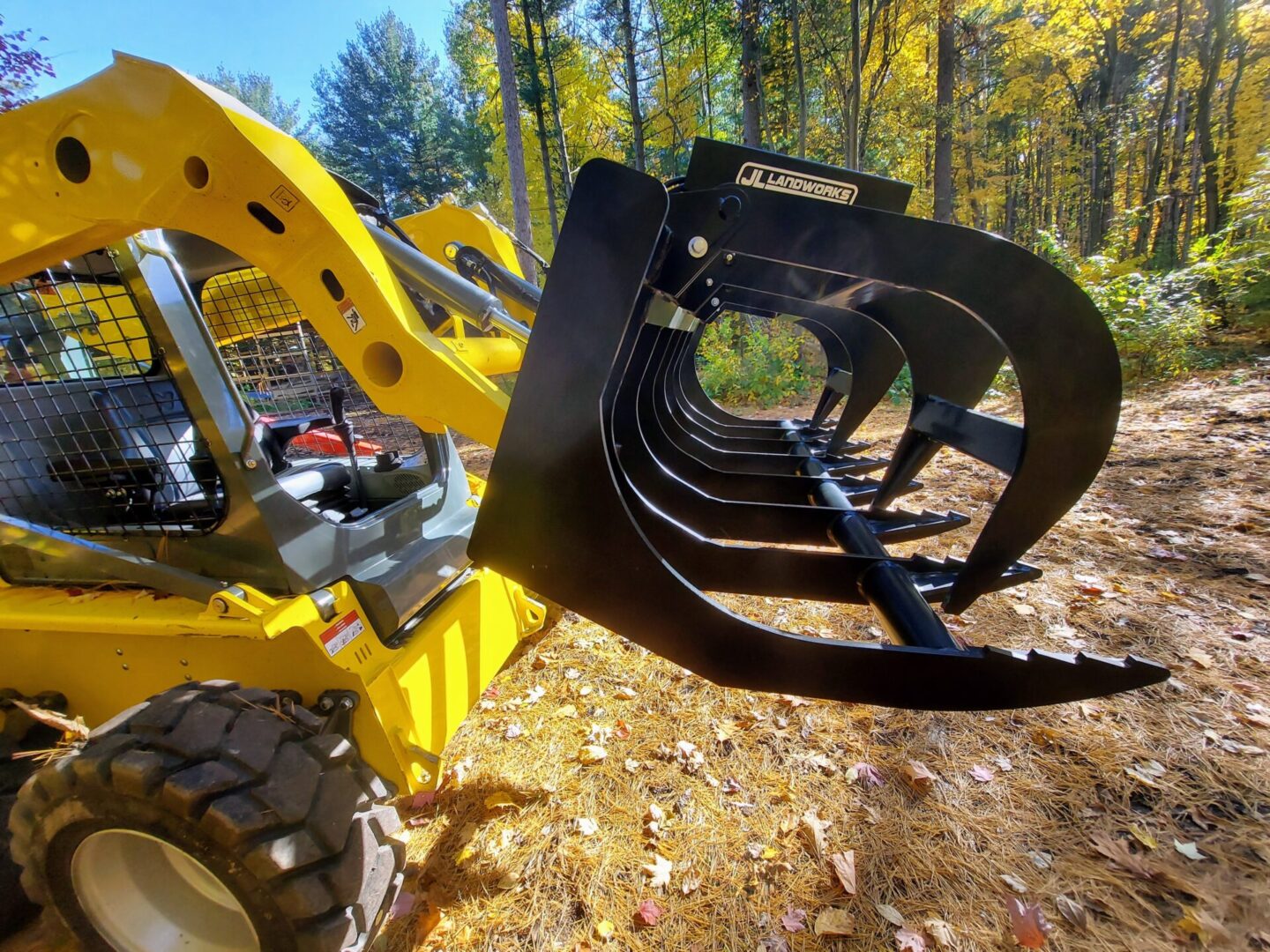 A yellow and black tractor with a large metal claw.