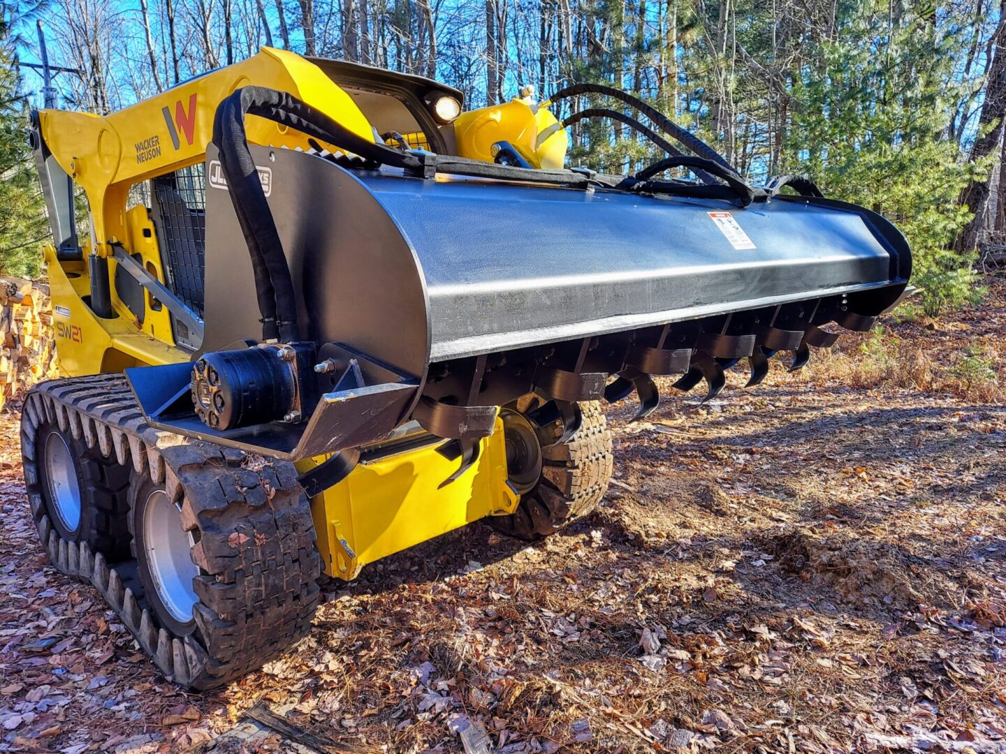 A yellow and black tractor with a metal plow attachment.