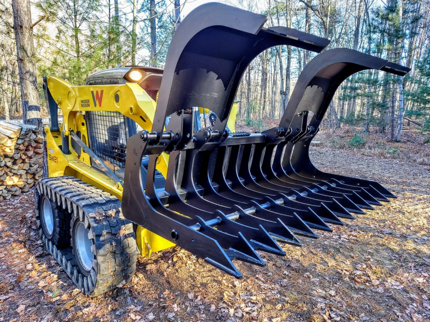 A yellow tractor with a large metal grapple.