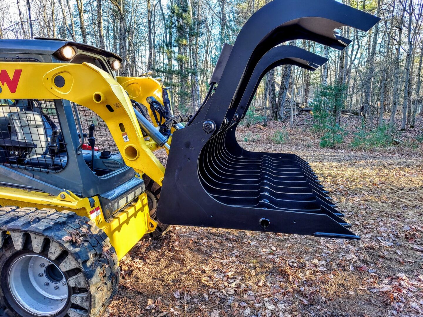 A close up of the back end of a yellow and black skid steer.