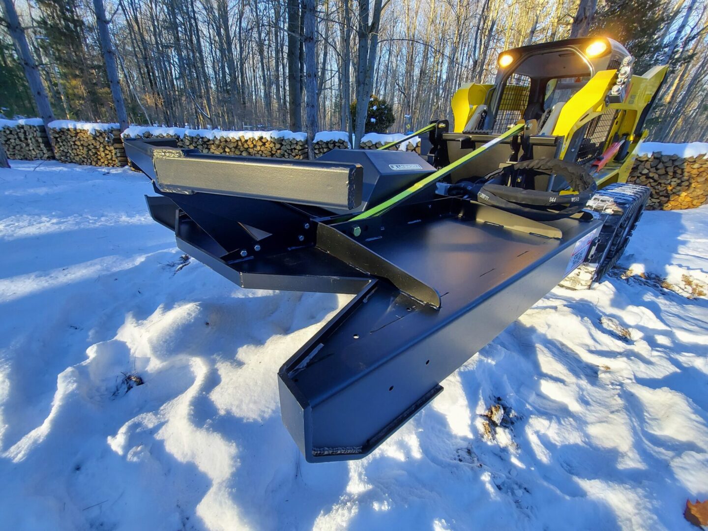 A snow plow is parked in the snow.