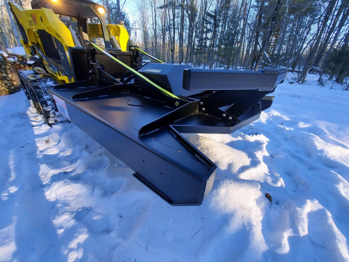 A snow plow in the middle of a snowy field.