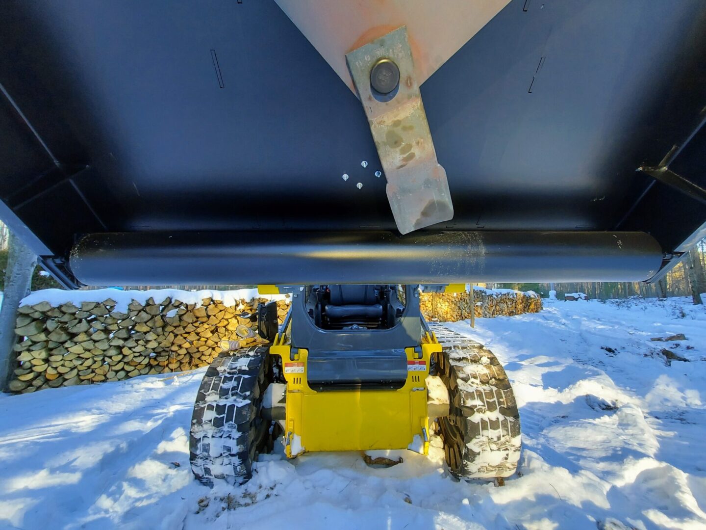 A yellow and black vehicle in the snow.