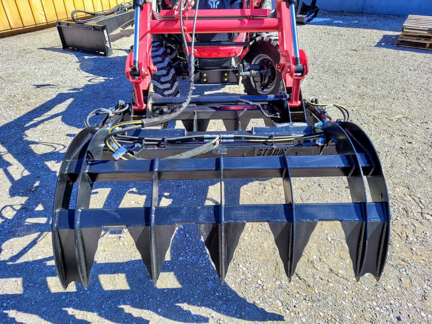 A tractor with a large metal plow attachment.