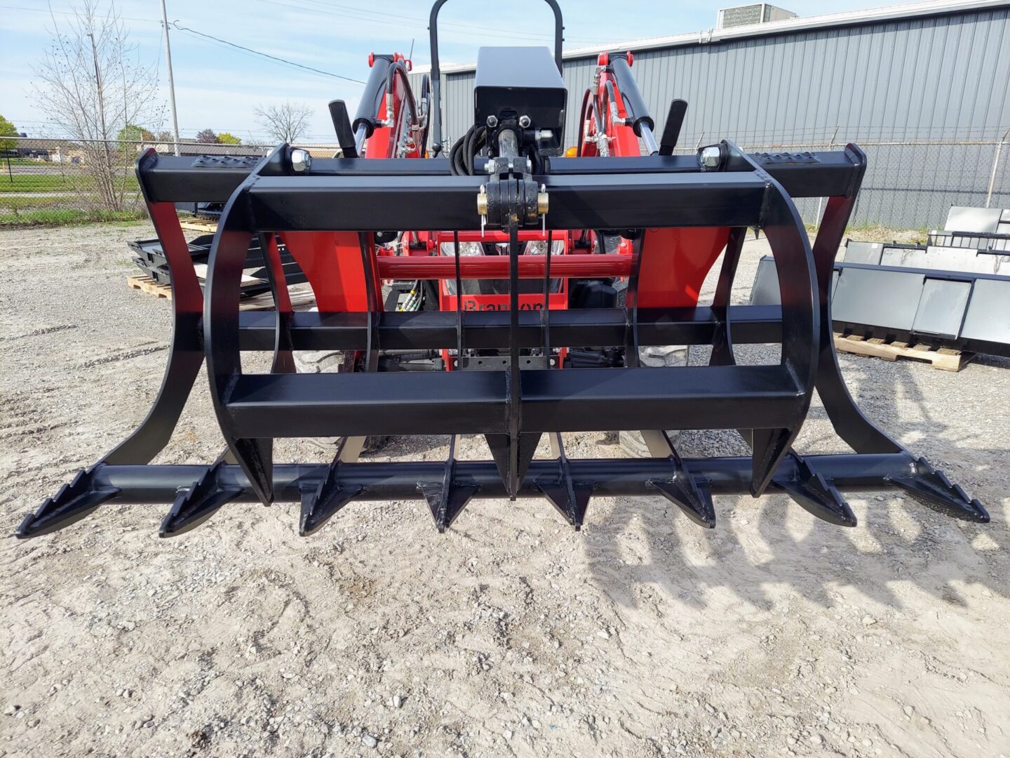 A tractor with a large metal claw attachment.