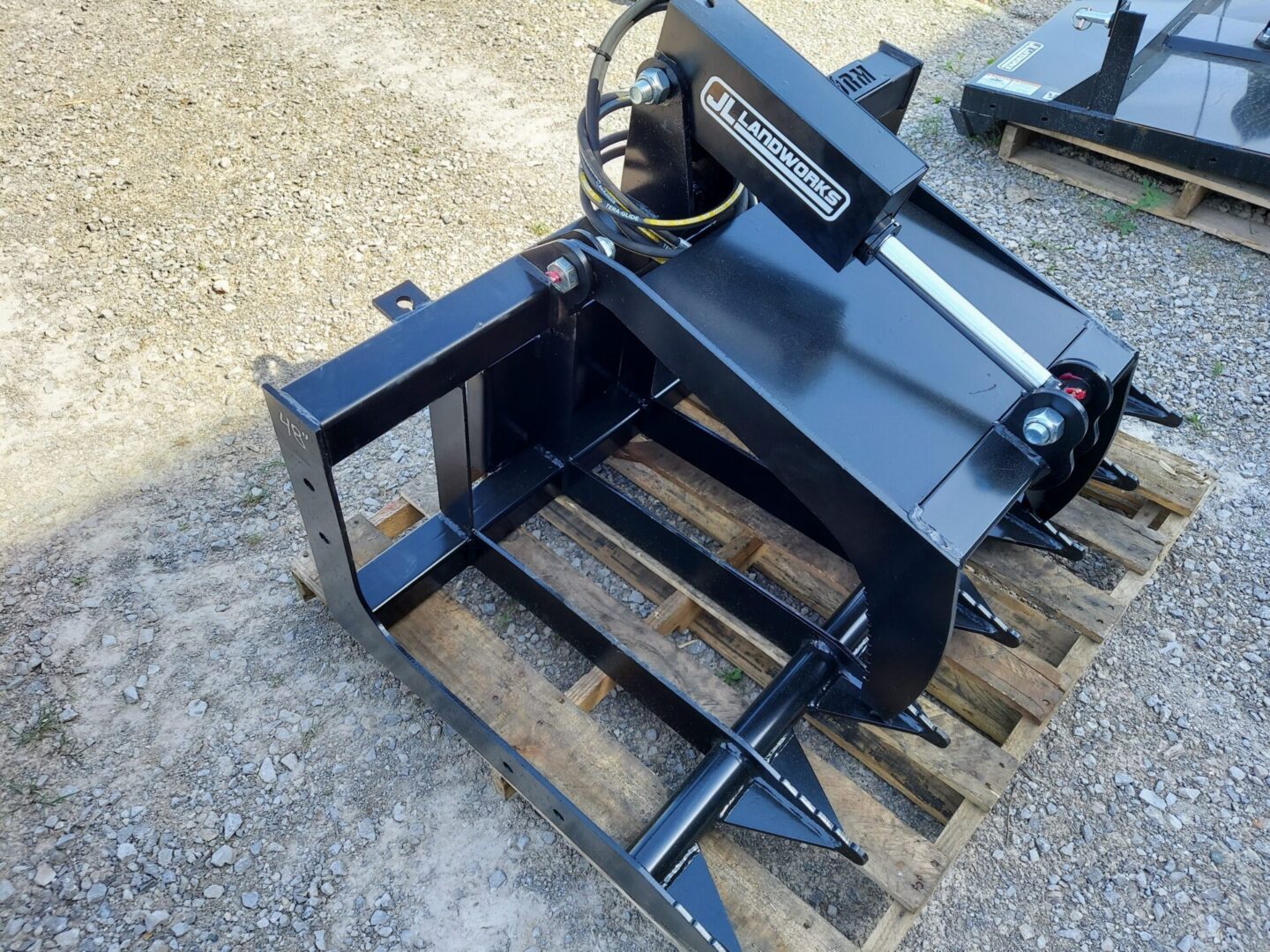 A black metal machine sitting on top of a wooden pallet.