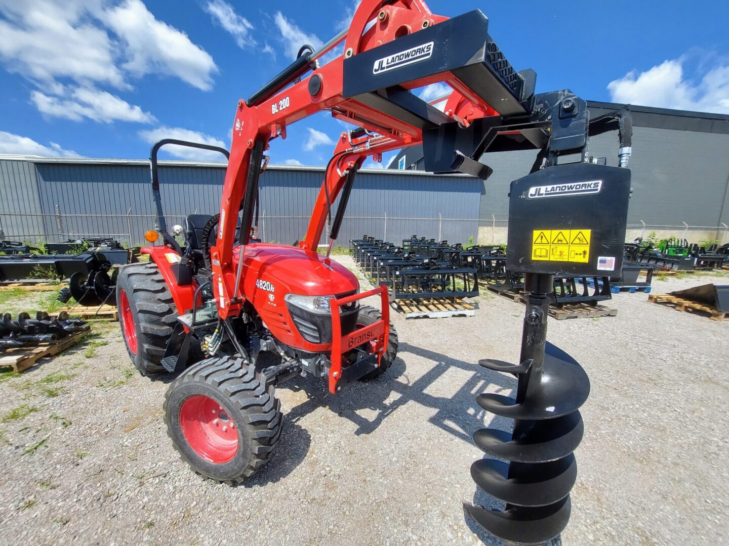 A red tractor with a black post and a blue sky