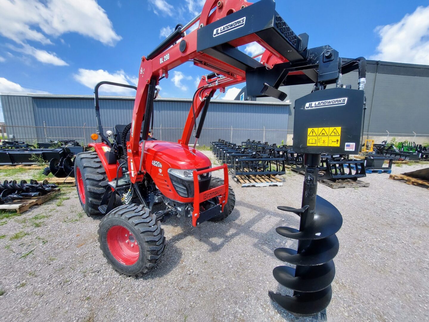 A red tractor with a black post and a blue sky