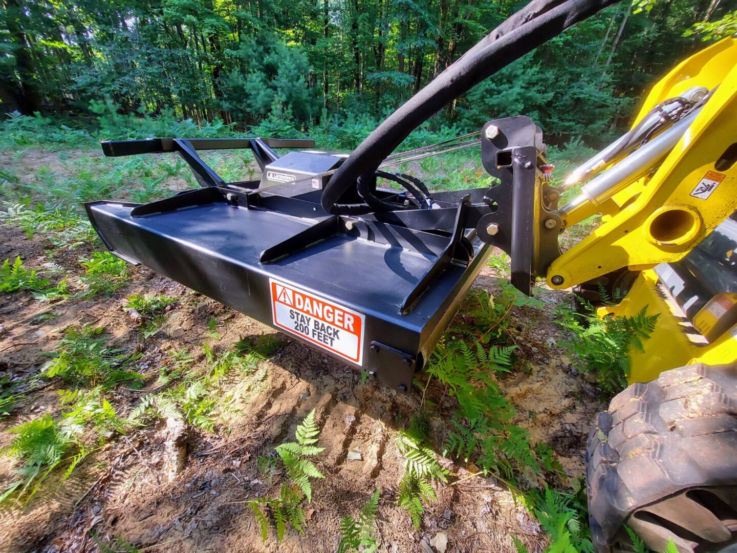 A yellow and black tractor with a plow attachment.