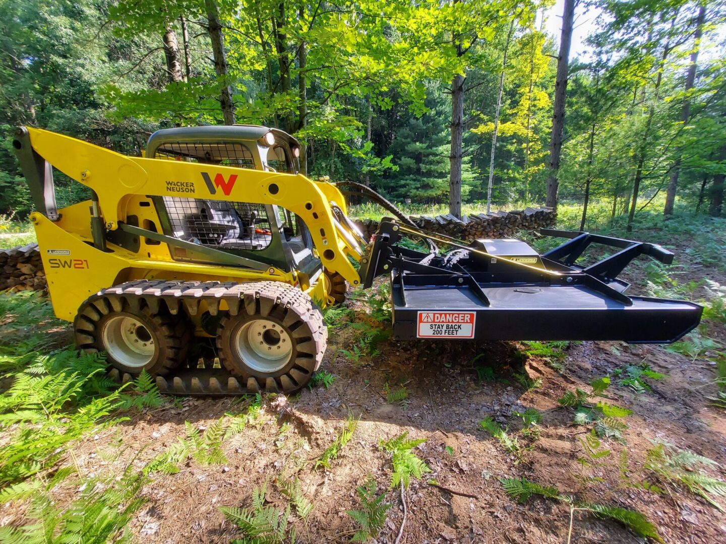 A yellow and black tractor pulling a trailer