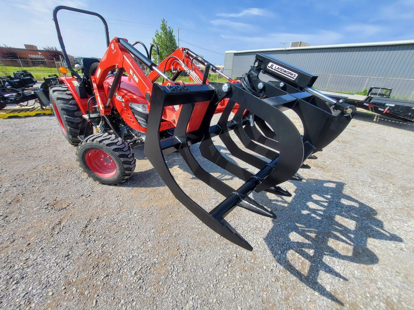 A tractor with a large claw attachment on the back of it.