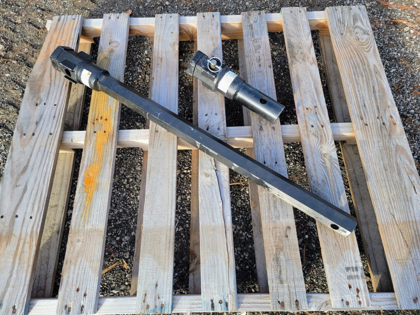 A wooden pallet with two pieces of metal.