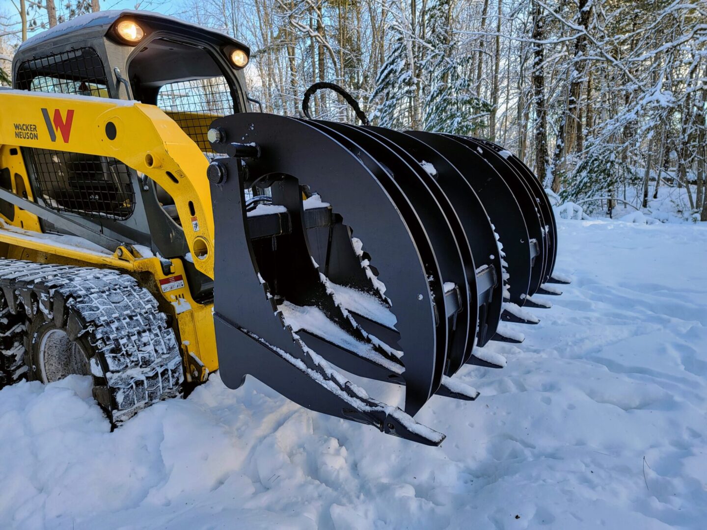 A yellow and black tractor in the snow.