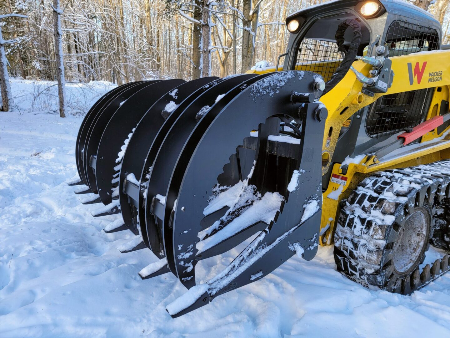 A yellow and black tractor with snow on it