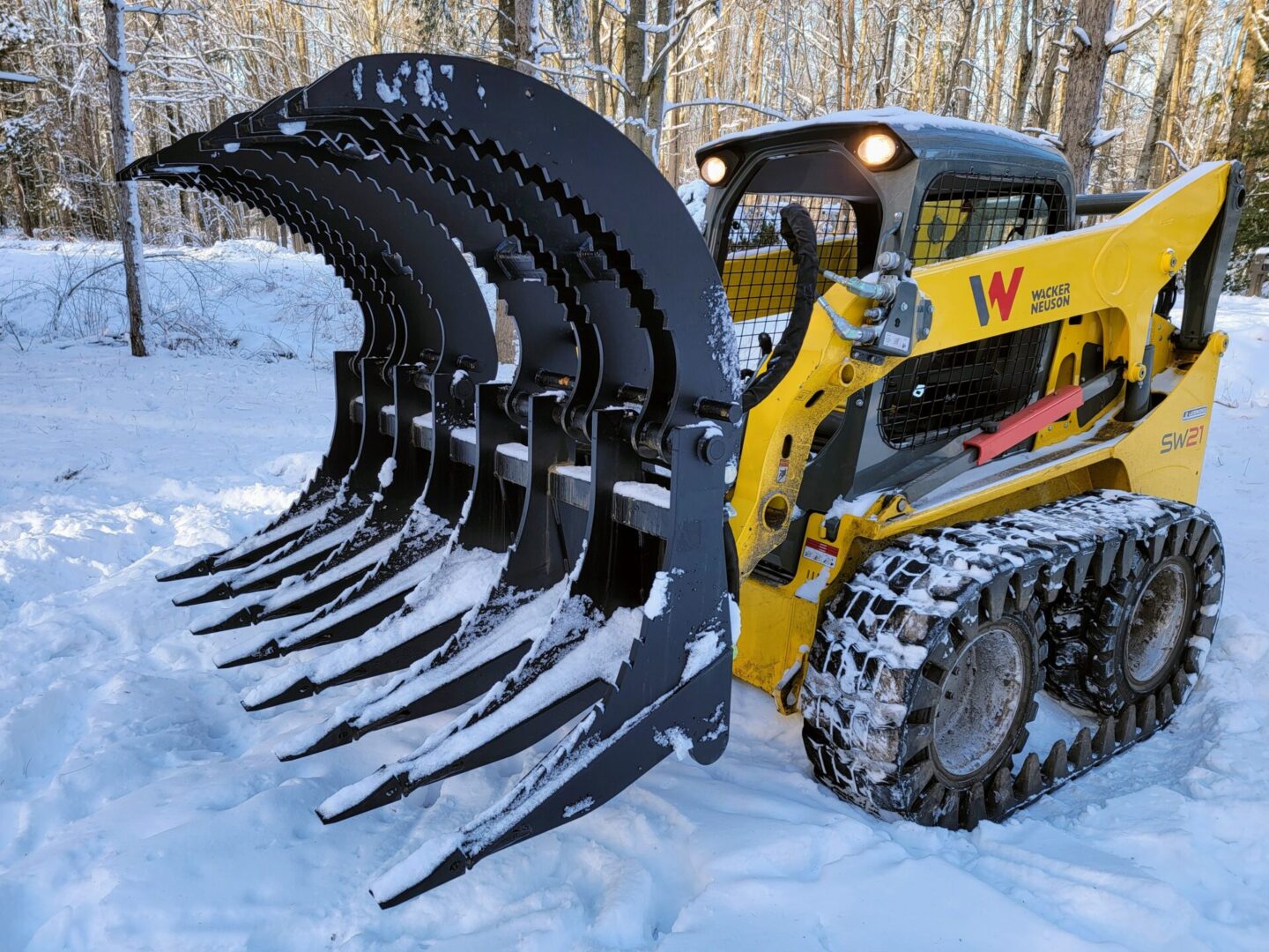 A yellow and black tractor with a large claw attachment.