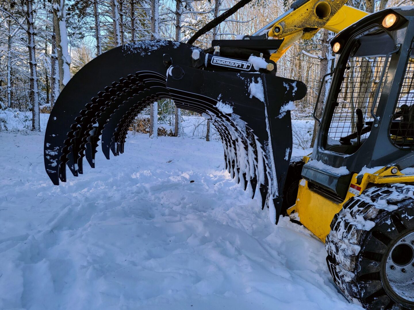 A yellow and black tractor is in the snow