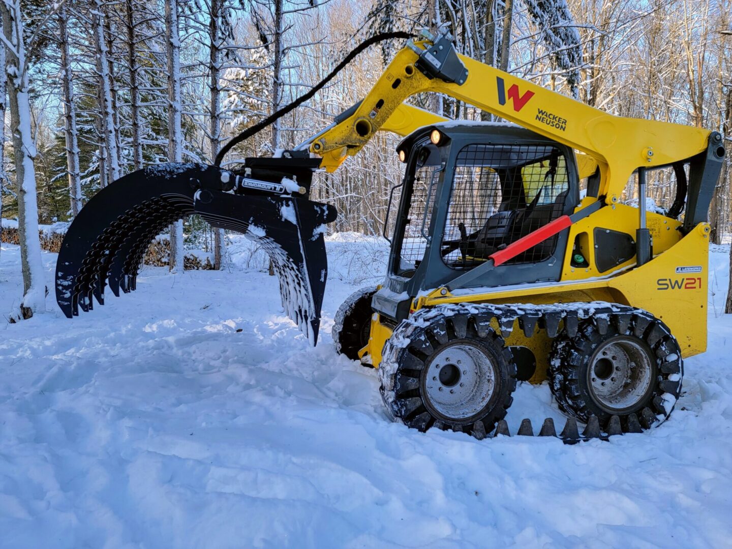 A yellow and black tractor is in the snow