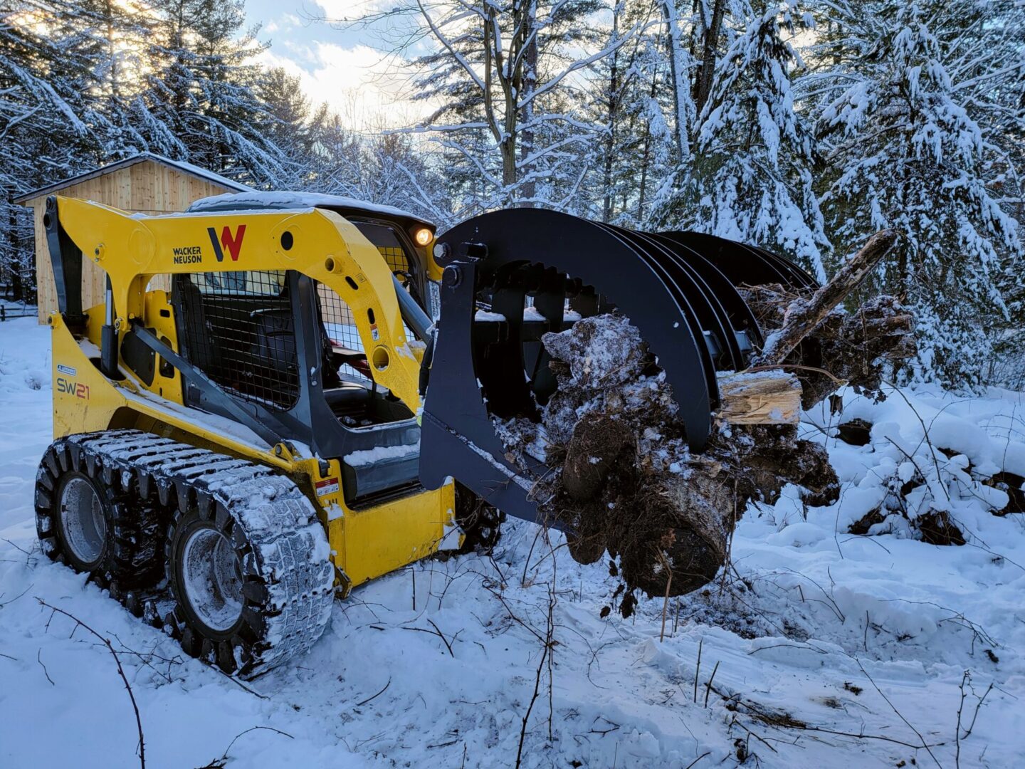 A yellow and black tractor is in the snow