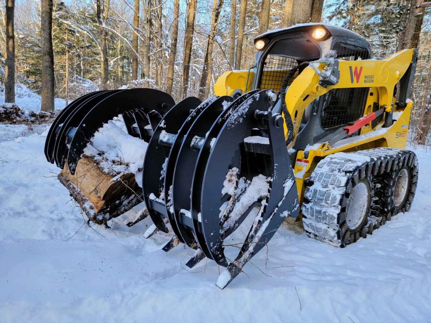 A yellow and black tractor with snow on it