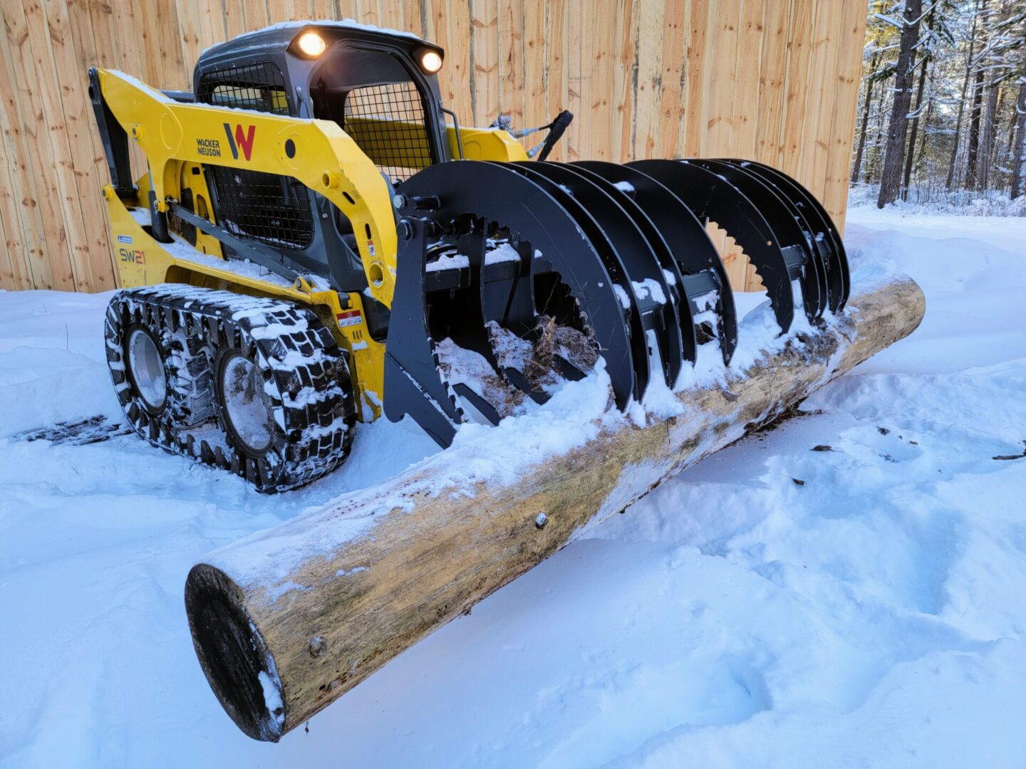 A yellow and black tractor is in the snow