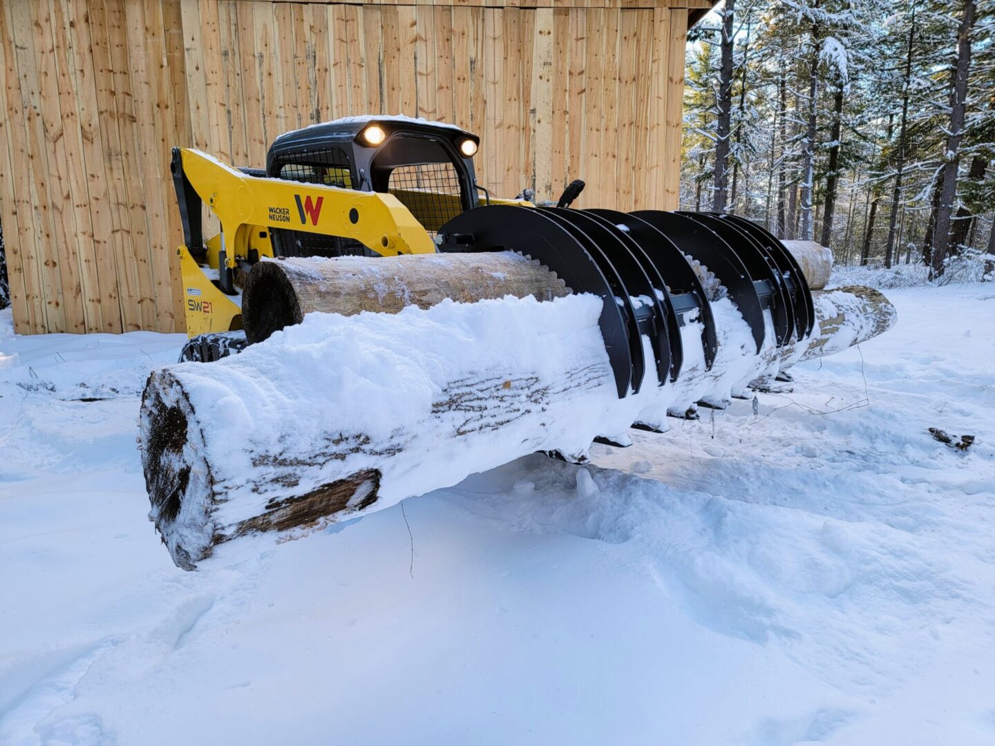 A yellow and black tractor is parked in the snow