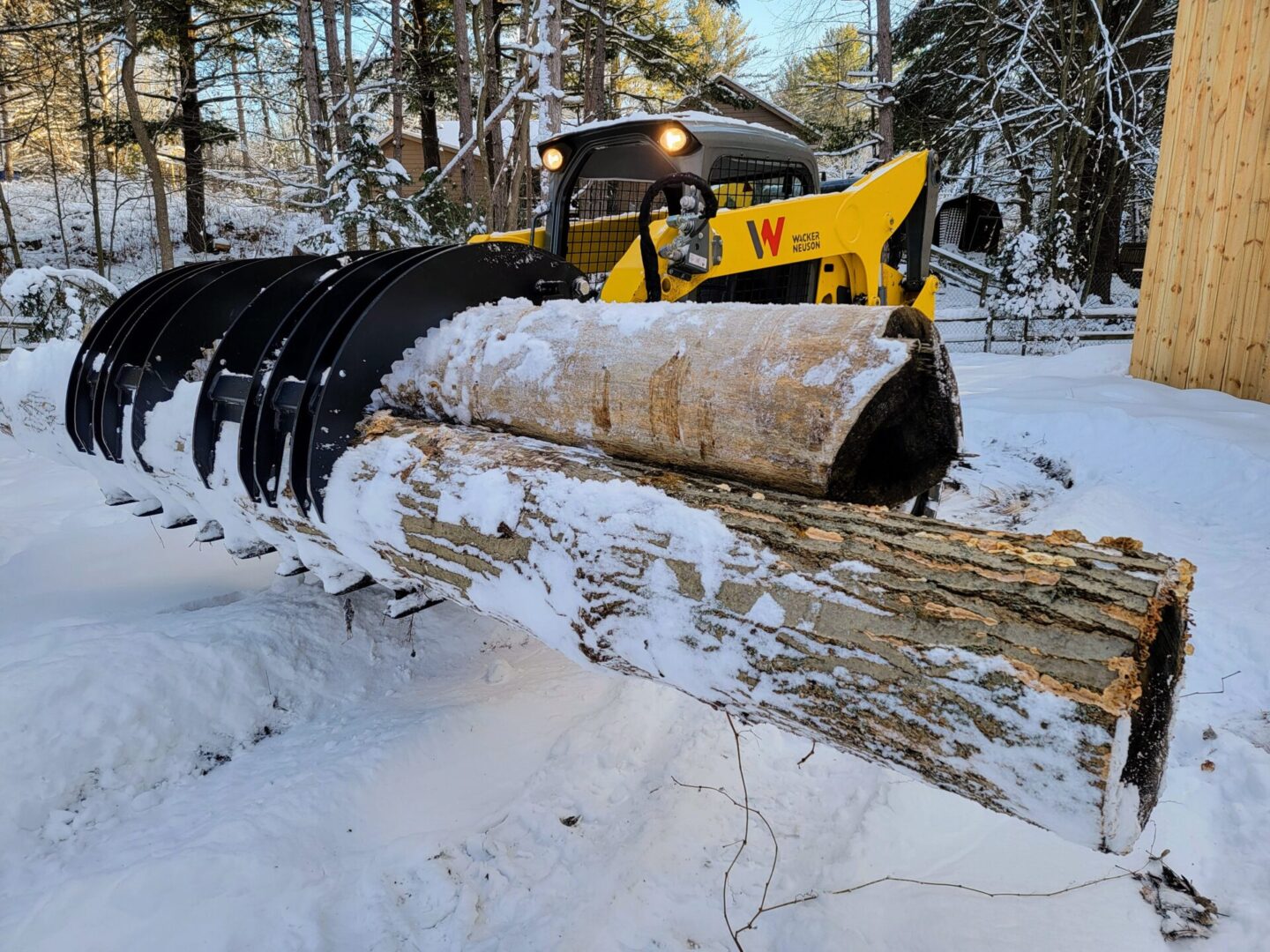 A yellow and black tractor is in the snow