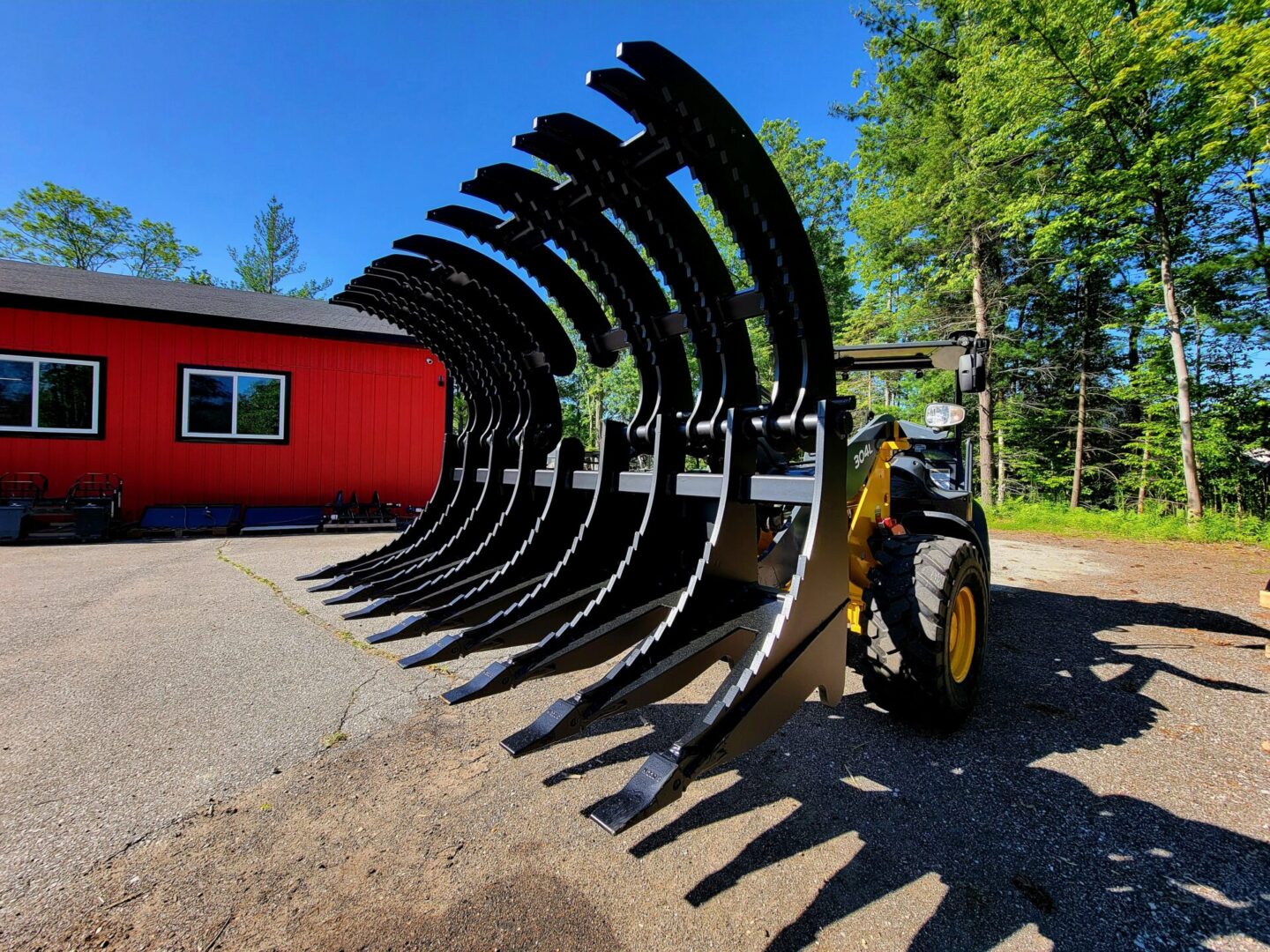 A large yellow tractor with a red shed in the background.