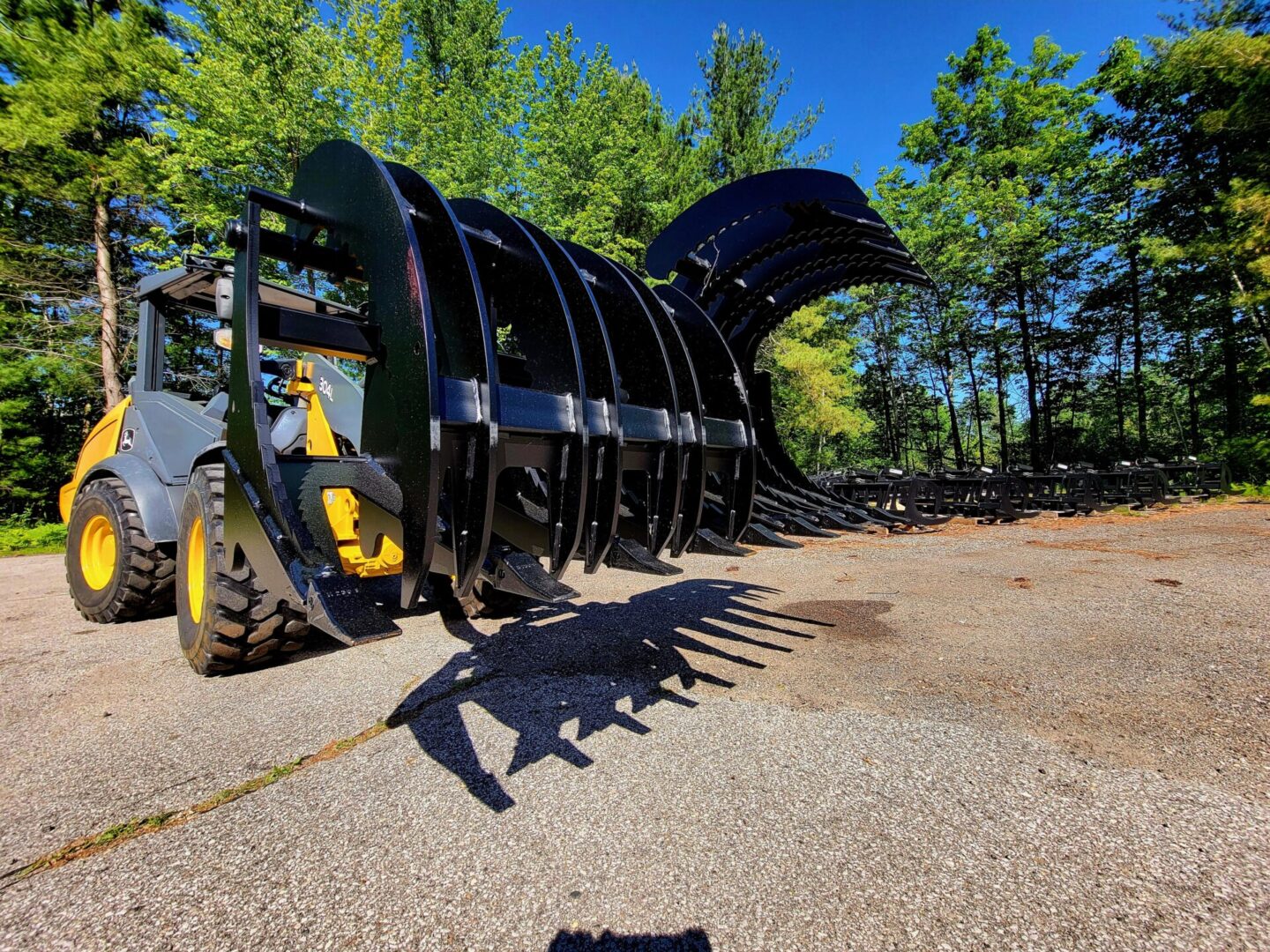 A large black and yellow tractor with trees in the background