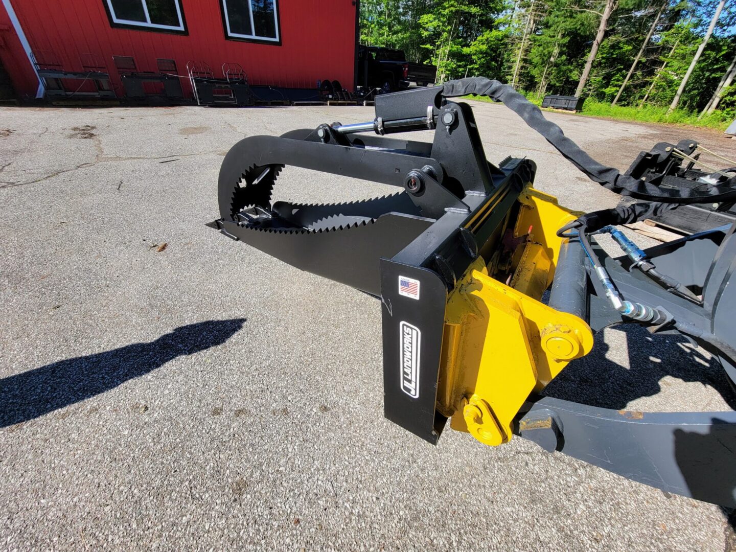 A yellow and black plow sitting in the middle of a driveway.