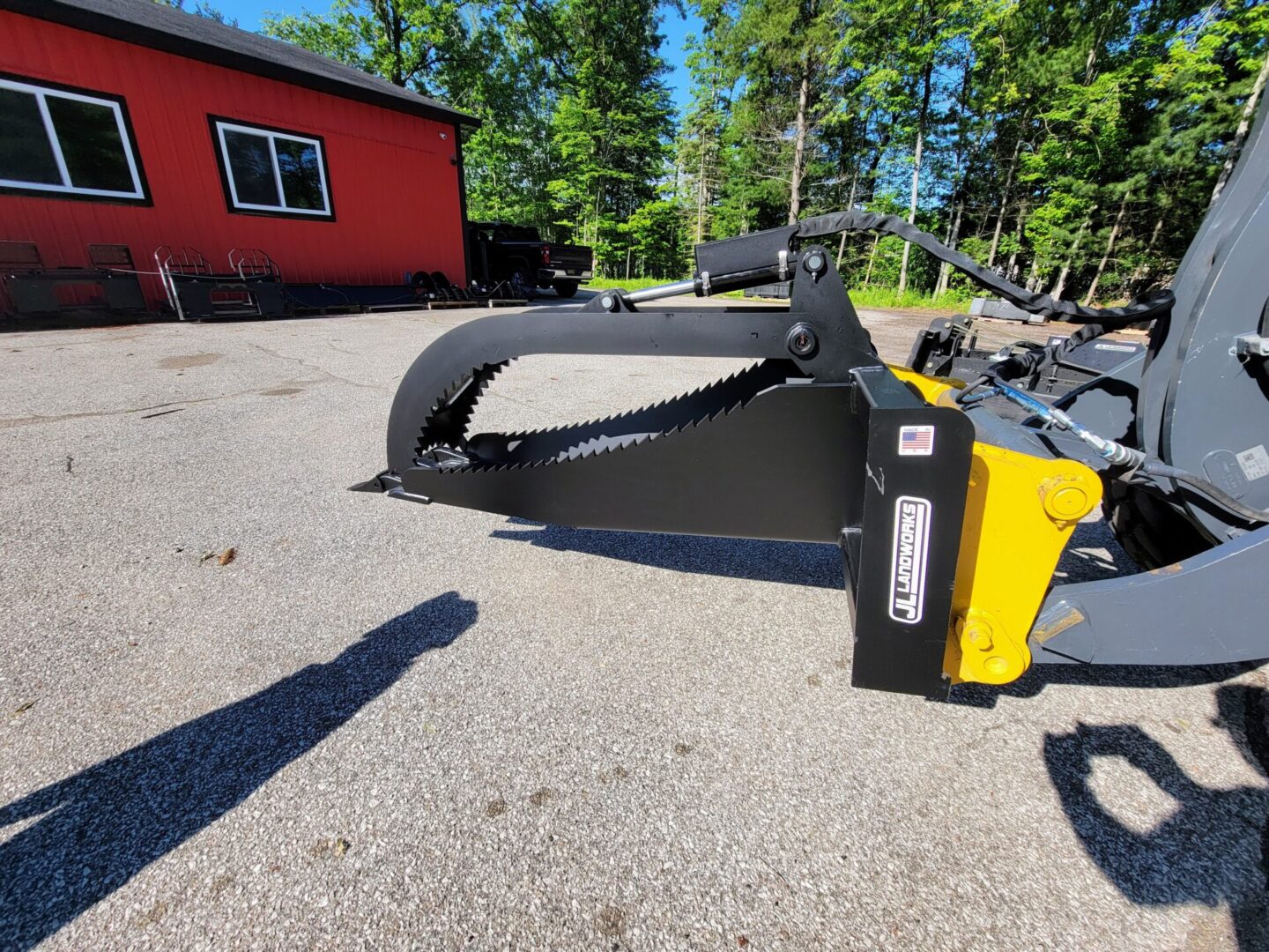 A yellow and black plow sitting in the dirt.