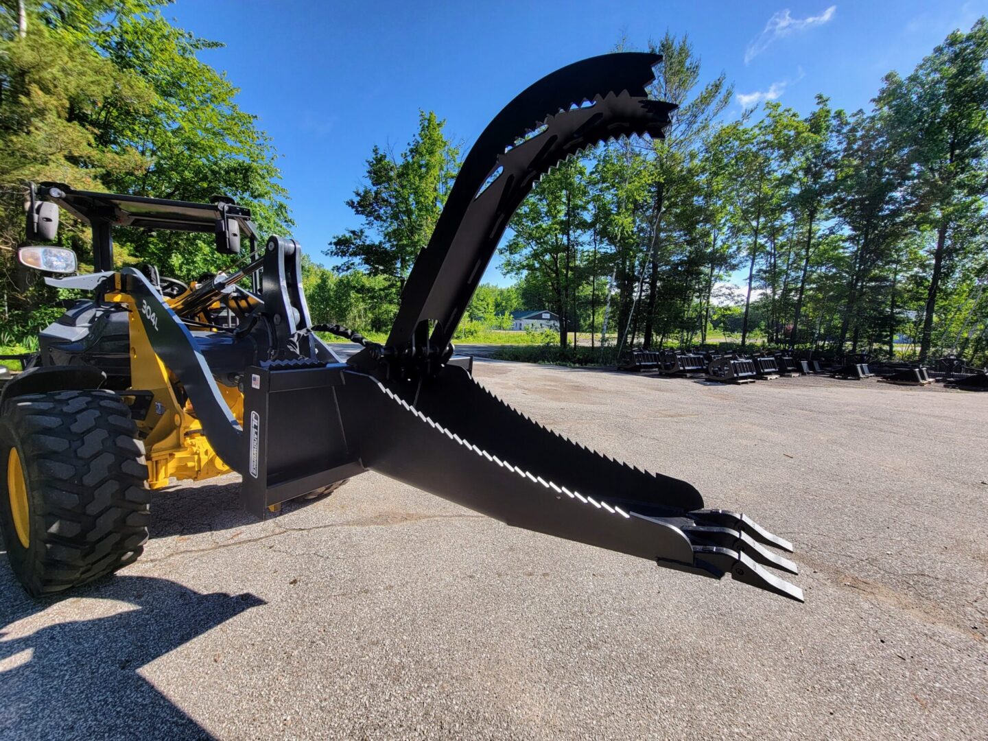 A large claw is attached to the back of a tractor.