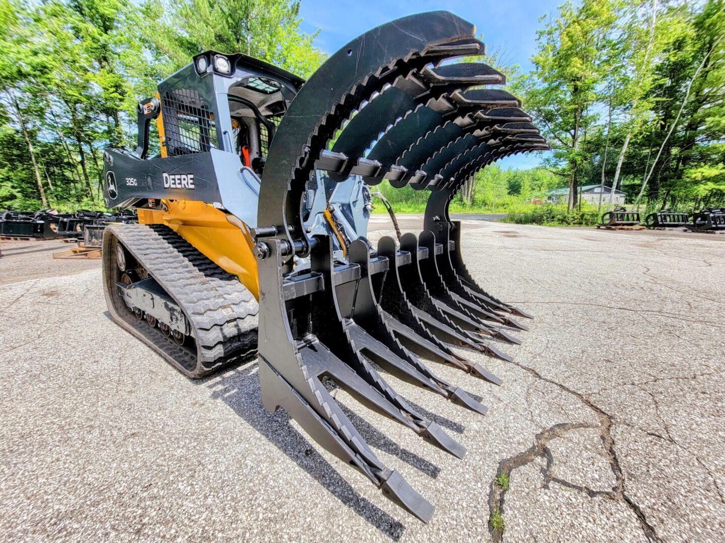 A large black and yellow tractor with a bunch of trees in the background