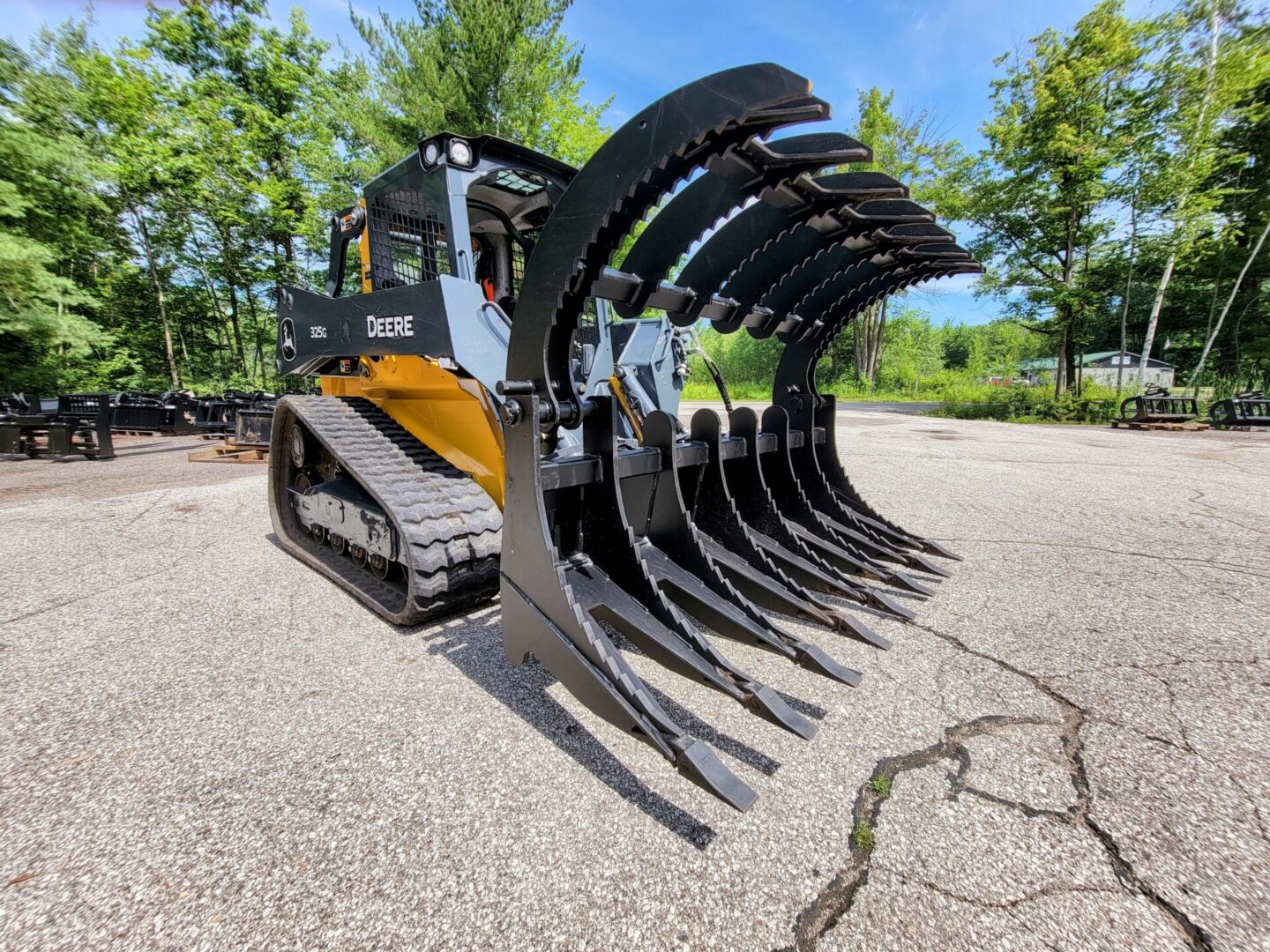 A large black and yellow tractor with a bunch of trees in the background