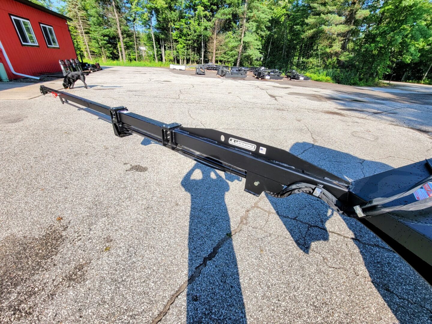 A long black pole sitting in the middle of a road.