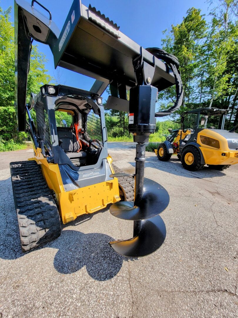 A yellow and black tractor with a large attachment.