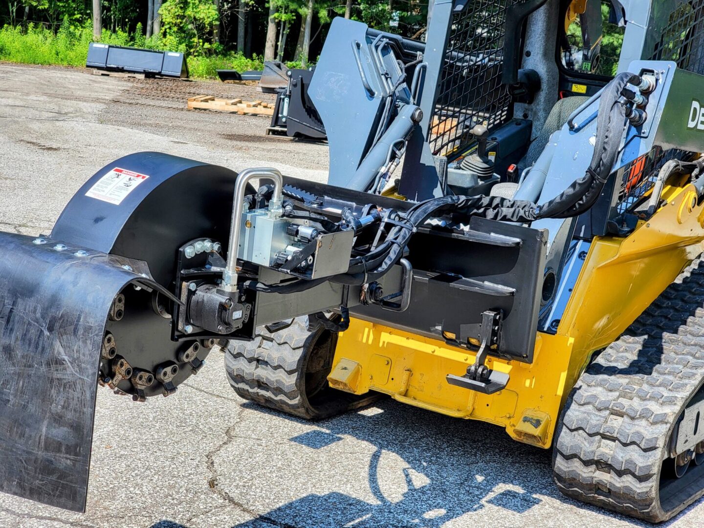 A yellow and black tractor with a plow attachment.