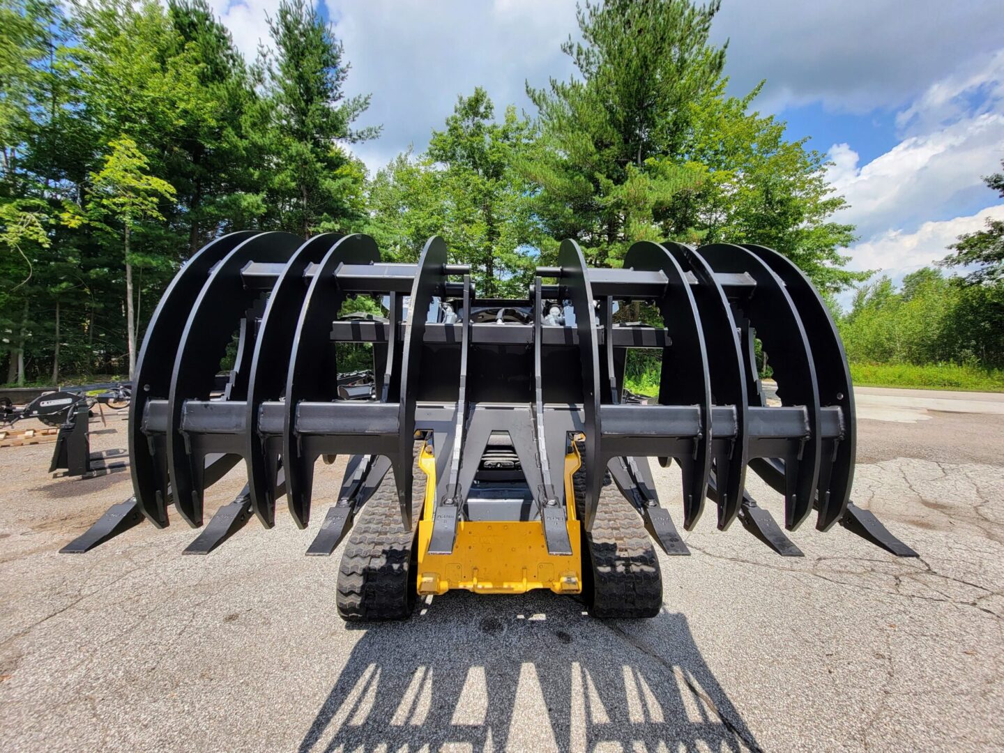 A yellow and black tractor with large metal forks.