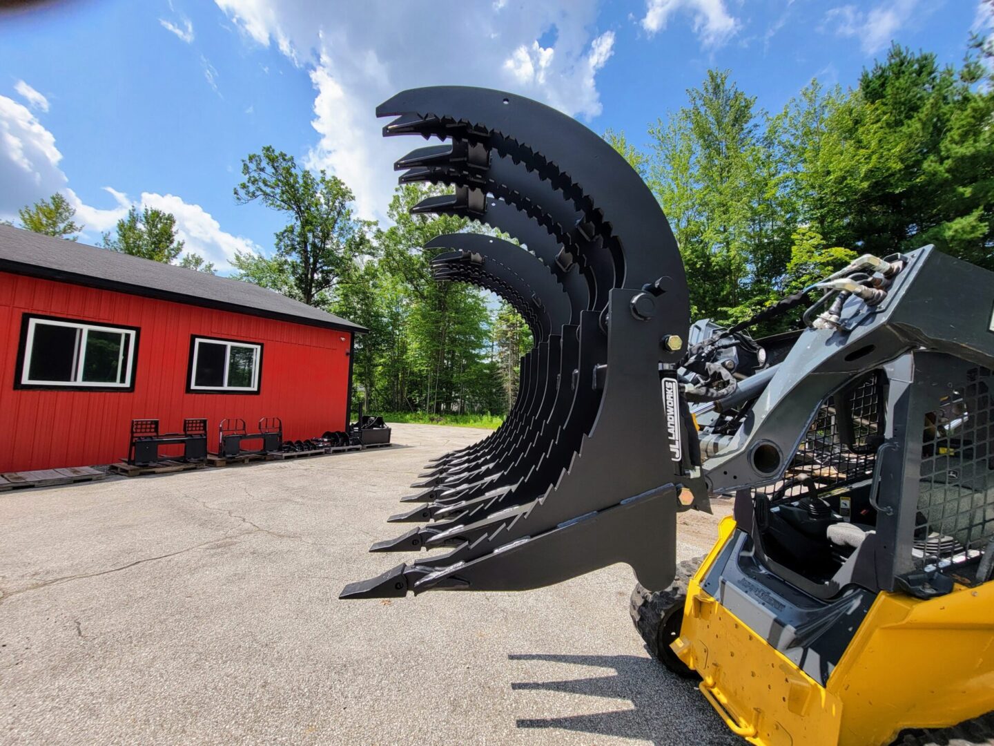 A large machine is parked in front of a red house.